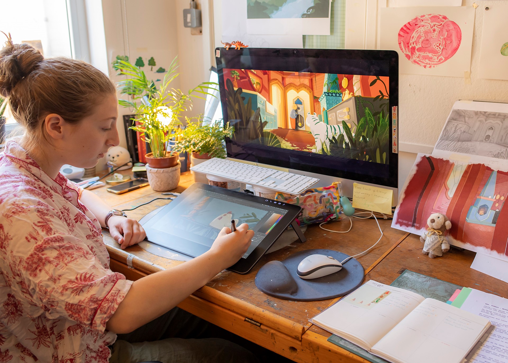 A woman works on a tablet with a screen in front of her