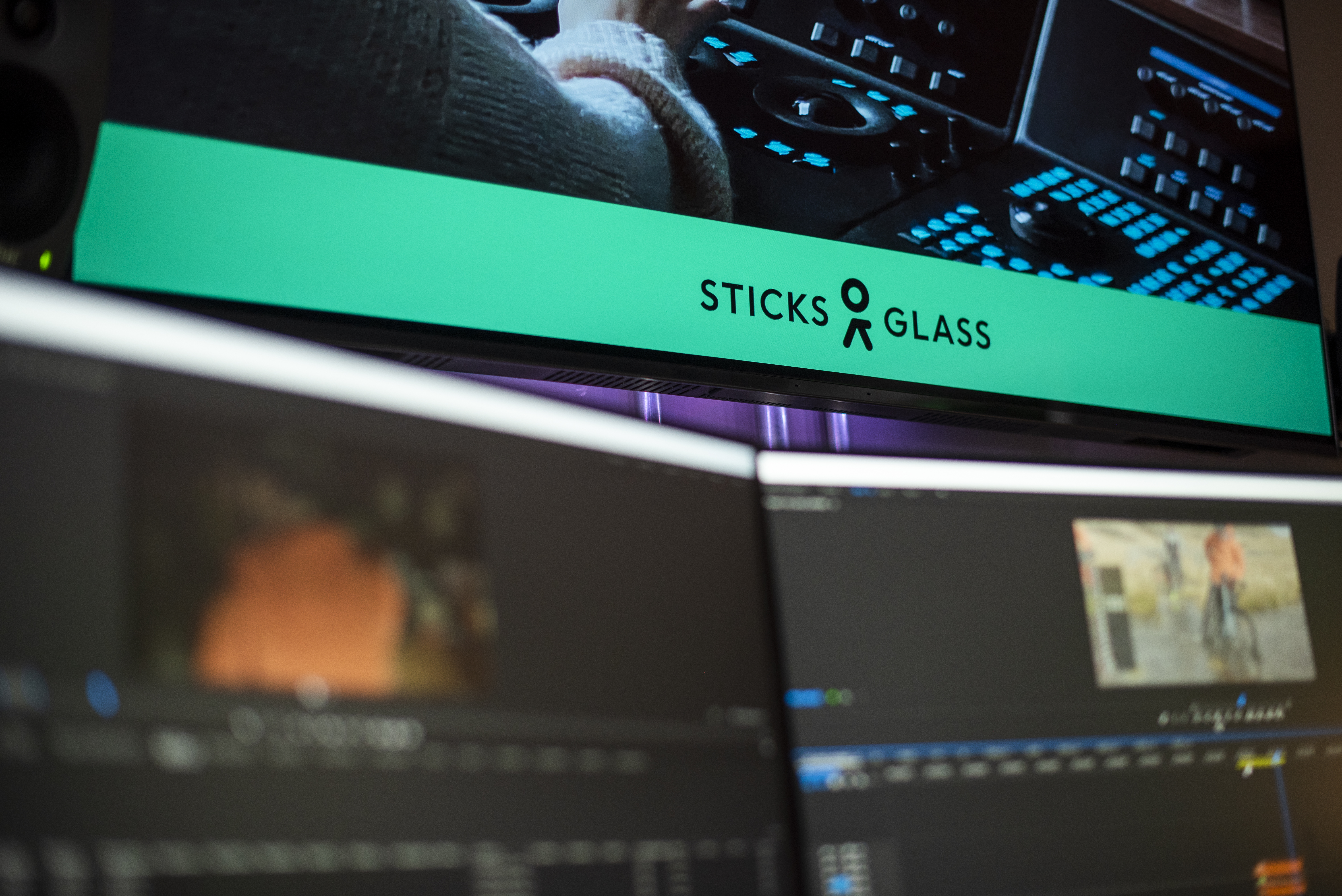 A closeup of a video timeline and a sound mixing desk with the Sticks and Glass Hub logo overlaying the image