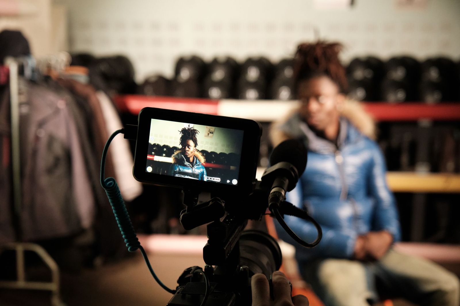 a man sits sits in front of a camera in a gym environment
