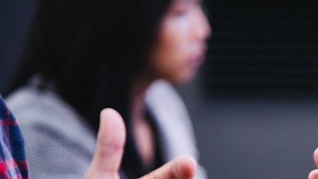 Hands gesturing in front of a laptop at a meeting