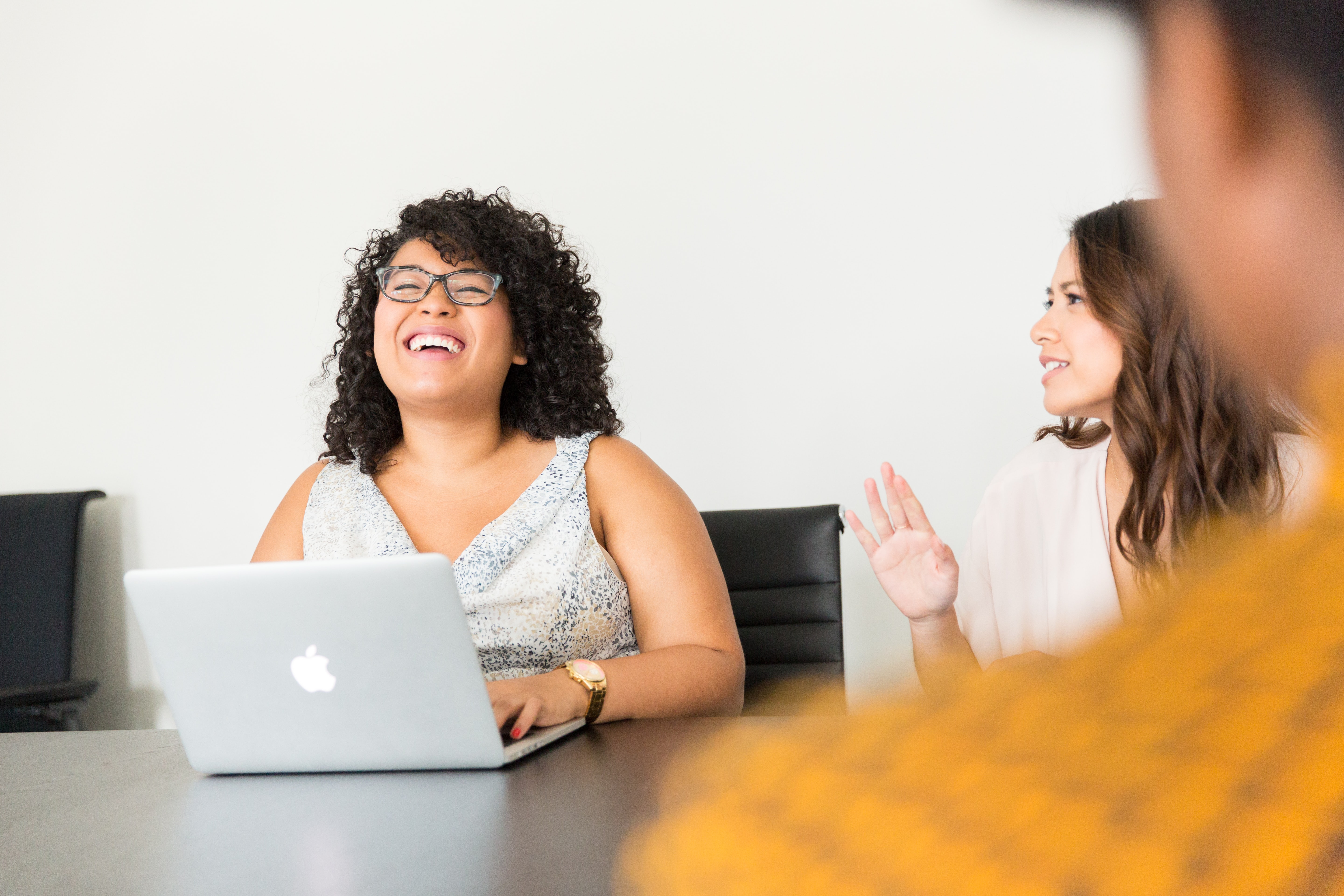 three people sitting around a table talking