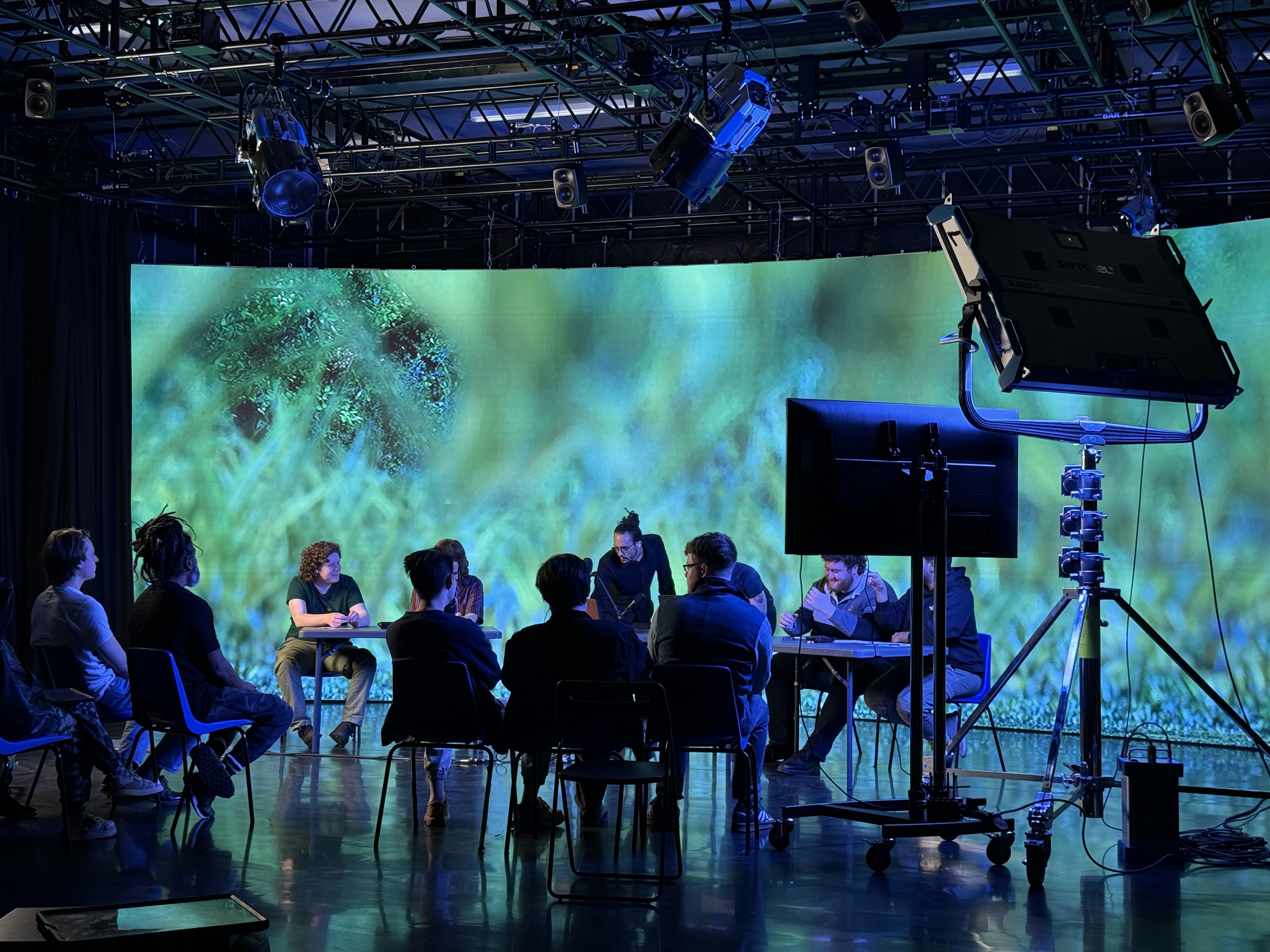 Group of people sat in a learning seminar in a  studio environment