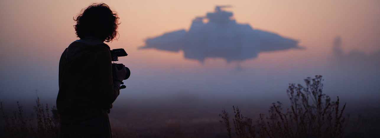 Person behind a camera looking at the sky