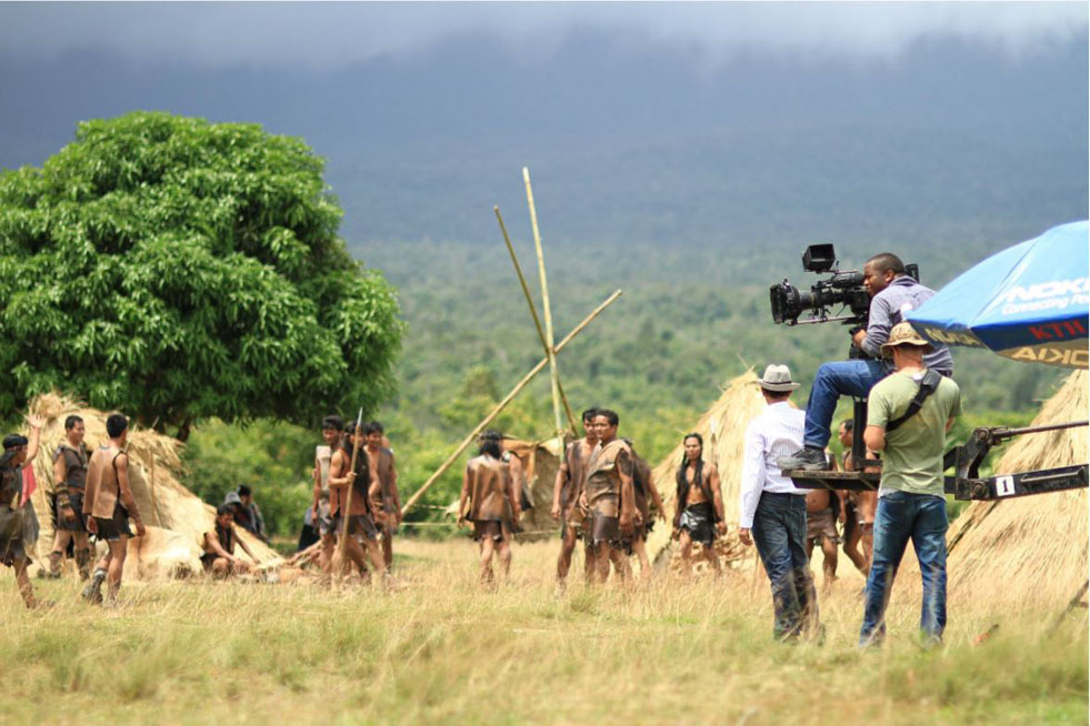 A team of actors and film crew on an outdoor safari set