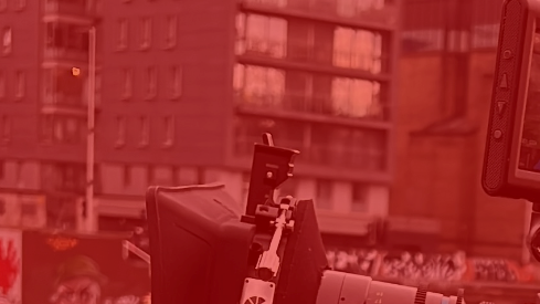 A man is shooting with a large camera